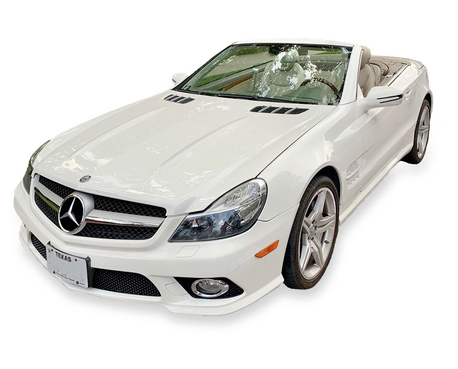 woman wearing wedding veil with pink accents smiling in front of white convertible mercedes car for rent wedding wheels dallas texas